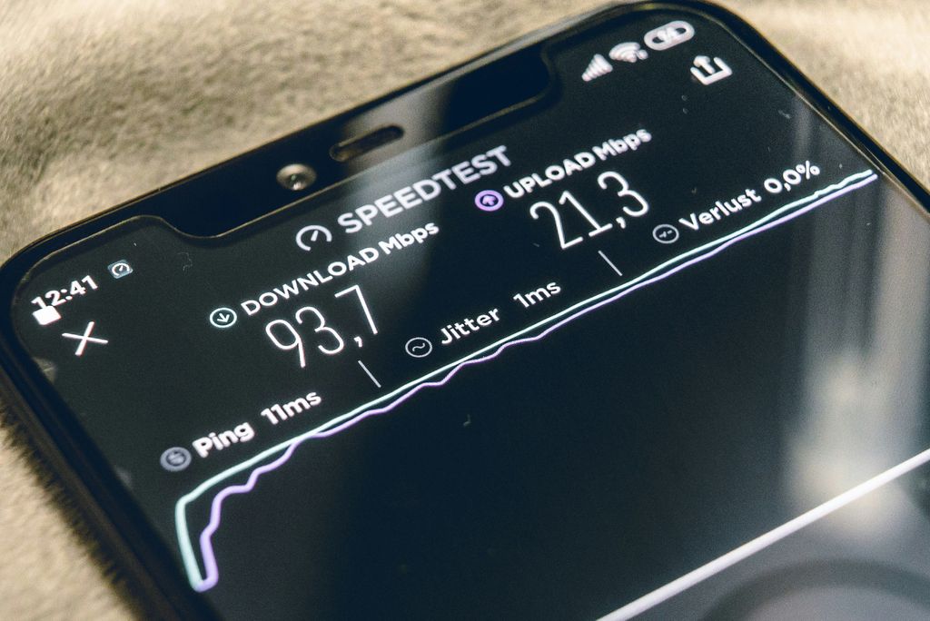 Smartphone mit 5G-Symbol in der Statusleiste vor einer Stadtkulisse