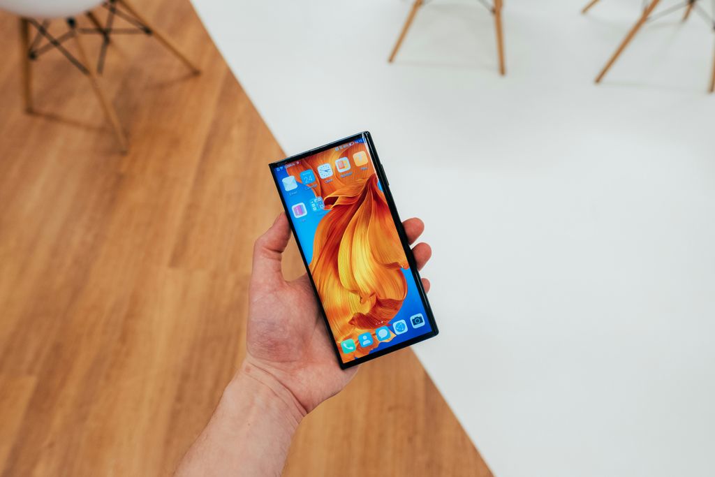 Ein aufgeklapptes faltbares Smartphone in der Hand vor neutralem Hintergrund