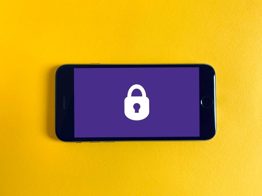 Hand hält Smartphone mit Sperrbildschirm und Schloss-Symbol